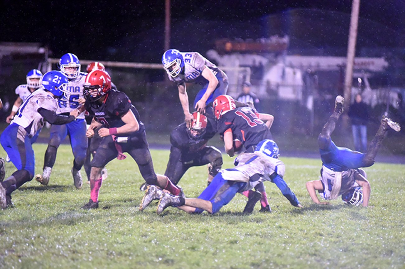 (Photo by Sue Michalak)                                Chaos strikes Davis Field during a contest against Tenino on Oct. 14, with Elma’s Niall Baxter (33) bounding over Tenino players.