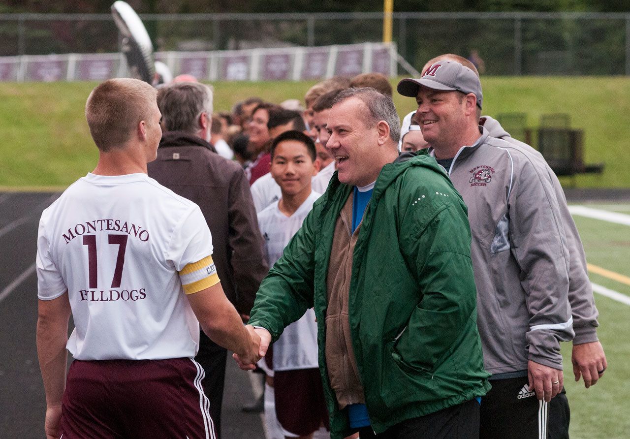 (Brendan Carl | Grays Harbor Newspaper Group) Mike Malpass, seen here shaking Kylar Prante’s hand during the Montesano boys soccer Senior Night ceremonies at Rottle Field in May, passed away on Monday after a long battle with cancer. He was 51.