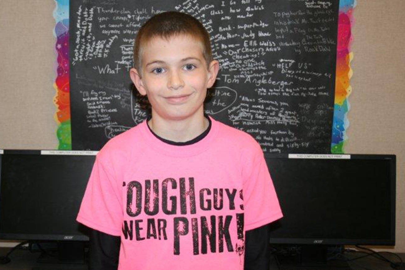 Ethan Haring, a sixth grader at Simpson School, poses for a photo while wearing his shirt in support of pink shirt day at Simpson School on May 1.