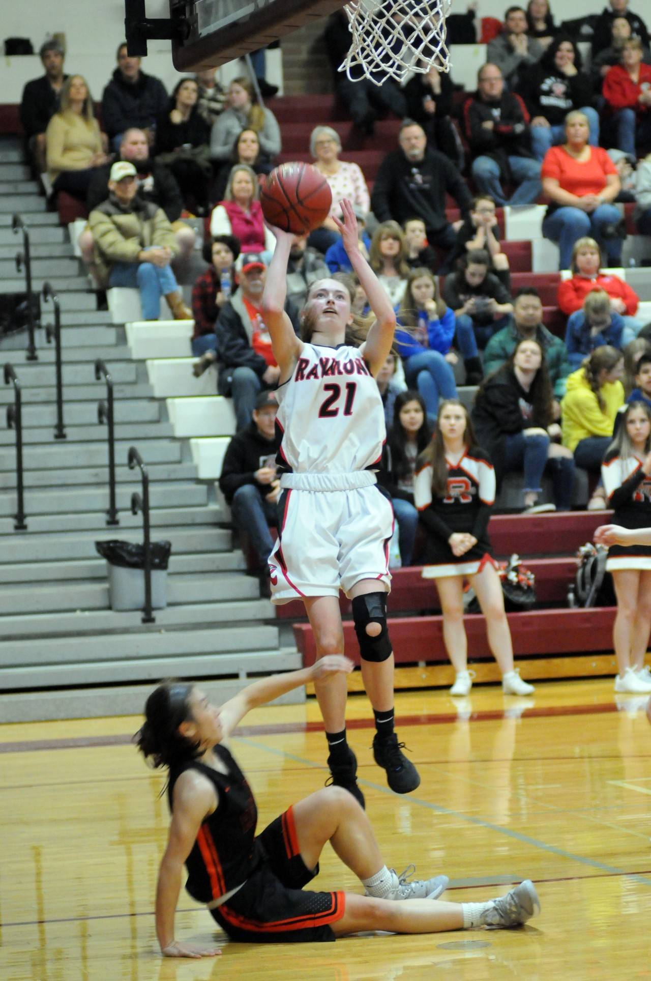 Raymond’s Kyra Gardner scored on a jump shot and Ranier’s Sophie Beadle falls to the floor during the Seagulls’ 59-46 loss in the 2B District 4 quarterfinals at Montesano High School. (Ryan Sparks | Grays Harbor News Group)