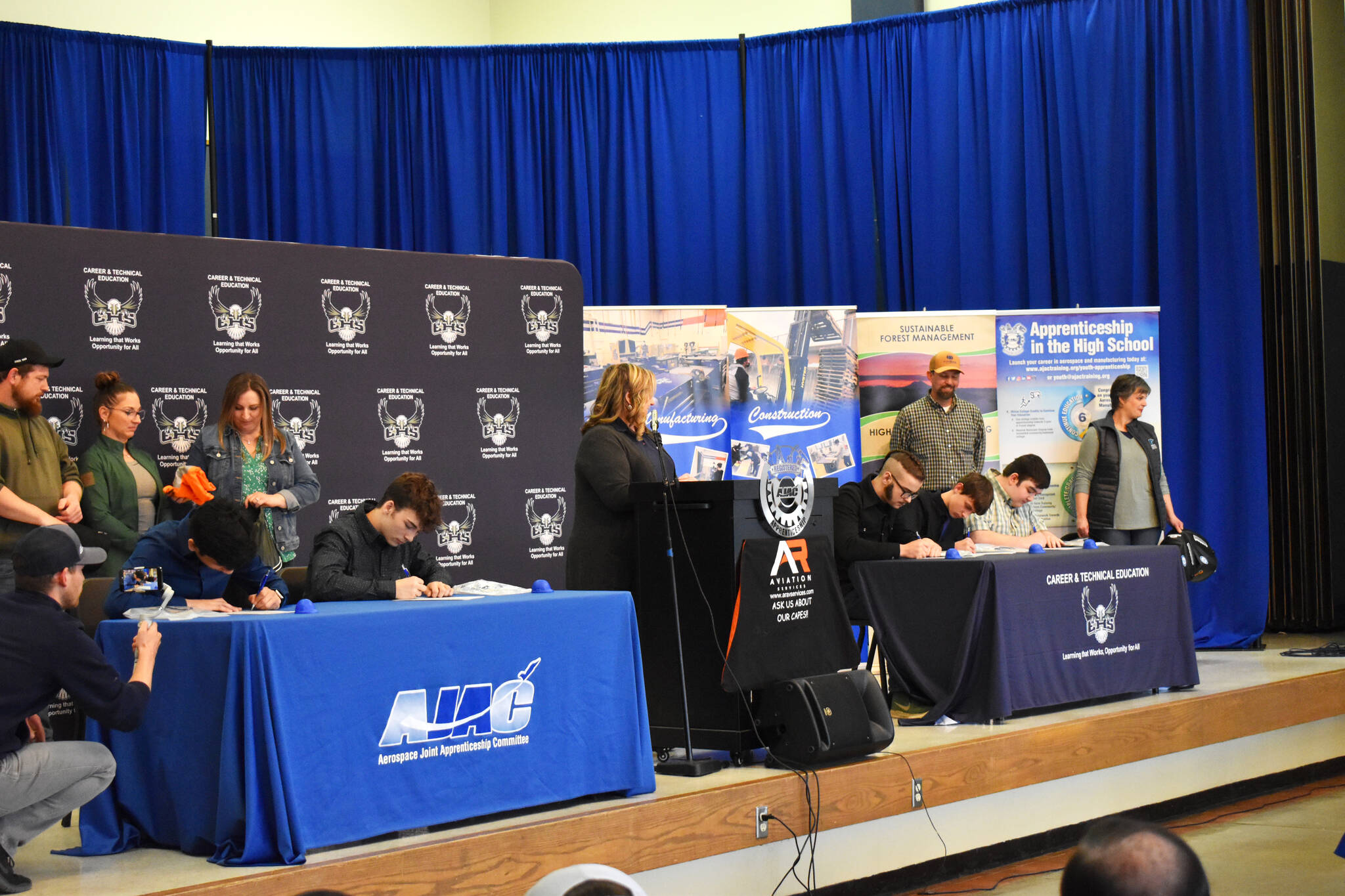 Allen Leister l The Daily World Students sign apprenticeship paperwork as their sponsoring company watches from behind during the AJAC Signing Ceremony at Elma High School on May 19, 2022, in Elma.